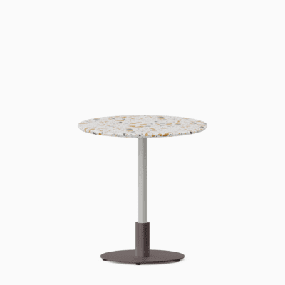 Round dining table with terrazzo top and metal pedestal base.