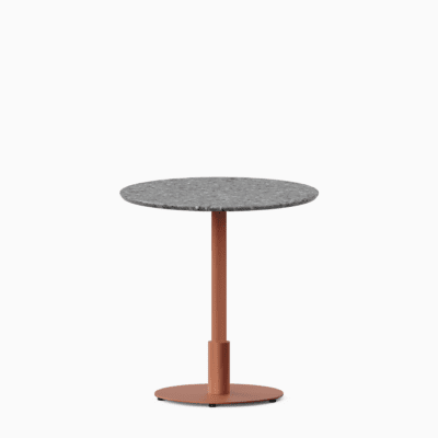 Round dining table with terrazzo top and metal pedestal base.