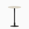 Round bar table with terrazzo top and metal pedestal base.