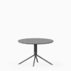 Round terrazzo table with speckled stone top and green aluminium base.
