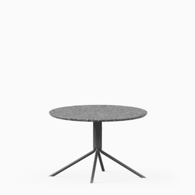 Round terrazzo table with speckled stone top and green aluminium base.